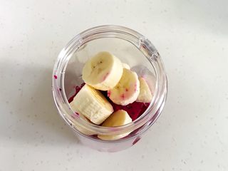 3、火龙果香蕉奶昔,香蕉切皮，切块放入。