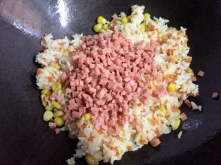 9、百变鸡蛋+蛋包饭,然后加入火腿肠丁翻炒均匀。