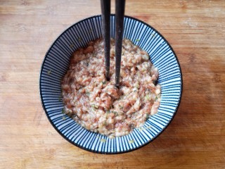 5、翡翠饺子——用一盘情意绵绵的饺子温暖整个冬天,将碗中的食材顺一个方向搅拌均匀,搅拌上劲儿(筷子在肉馅中能立住不倒)并用手将它们捏一下,帮助入味。捏好以后稍微尝一下肉馅的味道,根据自己的口味调整一下。然后,将肉馅放入冰箱中冷藏腌制一小时。