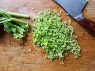 6、翡翠饺子——用一盘情意绵绵的饺子温暖整个冬天,将芹菜放入盛有清水的盘子中,再往水盆中加入一点食盐。用淡盐水浸泡芹菜,可以去除芹菜表面的农残。而且芹菜叶子上有时候会有小虫子,用盐水浸泡以后会将它们都逼出来。浸泡清洗后再用清水稍微冲一下就可以了。将芹菜沥干水分,然后切成碎末。