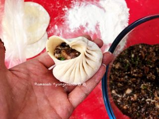 11、黑木耳肉末包子,右手食指和拇指提起面皮，像小时候折扇子样一褶一褶把包子皮往中间提起并压紧粘合，同时左手慢慢顺时针转包子，保持右手连续压褶，一般要有15个褶子以上才会比较漂亮，收口粘紧压实，依次把包子包好
