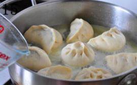 11、韭菜切肉水煎包,将稀面水沿锅边倒入锅中，没过包子大约1/3位置