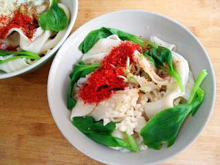 15、陕西油泼面,在上面放入葱花， 蒜末， 少许盐，鸡精 辣椒粉，花椒粉。