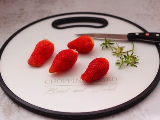 2、番茄草莓蜂蜜汁,用刀先把草莓的根蒂切出。