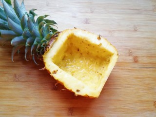 2、菠萝炒饭,挖完果肉的菠萝就变成了一个菠萝碗，在菠萝碗里面放一点点盐，倒入纯净水，浸泡5分钟左右倒掉淡盐水，用厨房用纸吸一吸菠萝碗里多余的水分。