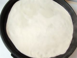 6、老妈酱香鸡蛋单饼卷,电饼铛预热后倒入一勺油擦一下锅，放入面皮，如果面皮太大拿不起来的话，可以先把面皮卷在擀面杖上然后移入电饼铛内