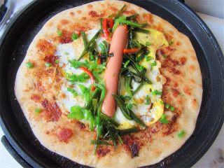 12、老妈酱香鸡蛋单饼卷,翻面撒上葱花、海带丝或韭菜碎。雪菜肉丝都可以，火腿肠放在中间，自己喜爱吃什么配菜可以放什么