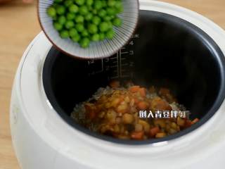 3、电饭煲懒人饭,还没出锅已经满屋子香味了,电饭煲倒入淘净的大米和煸炒过的蔬菜丁,再倒入青豆拌匀。