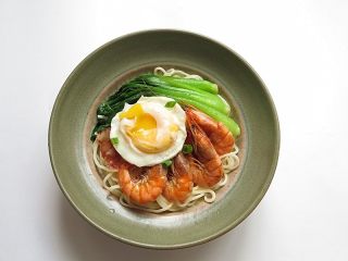 12、焖虾面,小青菜在油水锅内焯烫下，另外平底锅加几滴水煎好一个鸡蛋，将虾、鸡蛋、青菜用自己喜欢的方式码放好在碗里