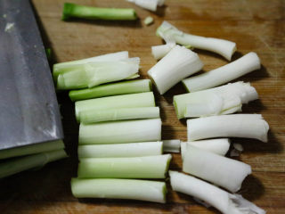 6、农家腊肠炝蒜,蒜白用刀拍松后，切成段。