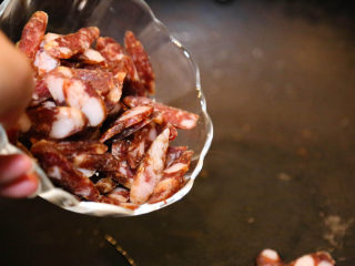 9、农家腊肠炝蒜,倒入腊肠。