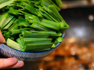 12、农家腊肠炝蒜,倒入切好的大蒜。