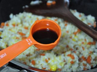 11、五谷杂粮炒饭,加入酱油勺,酱油可根据自己的口味适当增加,(关于酱油,一定要选择生抽,否则炒出来的颜色会很深。)