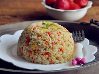 13、五谷杂粮炒饭,将炒饭装在一个比较深的小碗中,压紧后倒扣盘中,美味杂粮炒饭就可以上桌了,