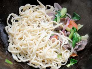 13、孜然牛肉炒拉条 家常面条百吃不厌的美味做法,过水后的面条倒入锅内。