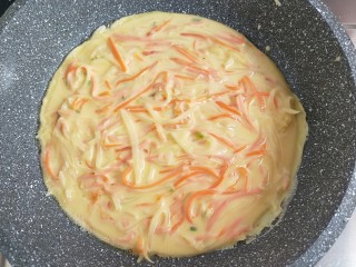 11、土豆丝火腿鸡蛋饼,平底锅刷油,小火。面糊倒进去,用筷子把三丝摊一下,尽量分布均匀一些。