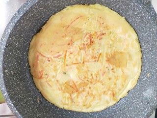 12、土豆丝火腿鸡蛋饼,煎好一面。翻面。再煎一会。