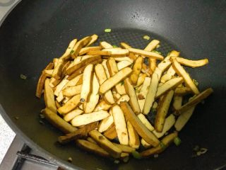 12、家常小炒韭菜香干,继续翻炒，待香干外皮焦黄，此时盐和鸡精块已完全融化，吸附在香干上。