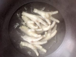 3、卤鸡爪,锅中放水烧开后，把鸡爪放入沸水锅中焯去血水。