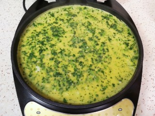 10、菠菜蛋卷,倒入菠菜蛋液，来回晃一下电饼铛，让蛋液铺满电饼铛底部，保证做出来的蛋饼薄厚均匀。