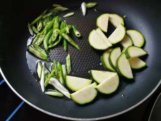 6、月半弯炒(拌)面,适量食用油7成熟时下葱白段、青椒斜片;因青南瓜片的厚度,需要早早下锅,这样全程会给其他食材浸入丝丝清甜;