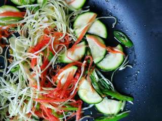 8、月半弯炒(拌)面,胡萝卜丝不停翻转(太细容易粘锅——不同的食物形状,会因为不同时段的加入,会有口感的层次差异),使食用油尽力粘裹胡萝卜丝(胡萝卜经油的烹调,才会更有营养也更容易被吸收)