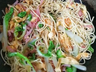 9、火腿鸡蛋炒面,然后下入面条快速翻炒几下;