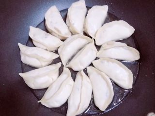 4、鸡蛋抱饺,饺子小火煎2两分钟。加入100ml水。