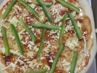 13、鲜虾火腿披萨,涂好酱后撒上一些马苏里拉芝士碎，放上青椒。