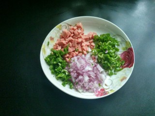 4、剩米饼,将火腿肠，青椒，香葱，洋葱切丁备用。