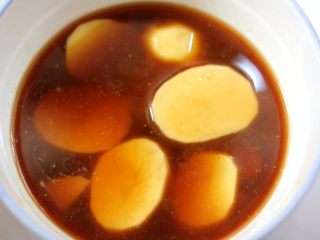 10、盐水焗蒸鸡,把切好的土豆片放入大碗底部,再倒入之前腌鸡的料汁淹没土豆片。