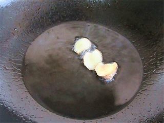 6、五花肉炒蒜薹,锅内注入油烧制6分热，放入姜片炸制金黄捞出