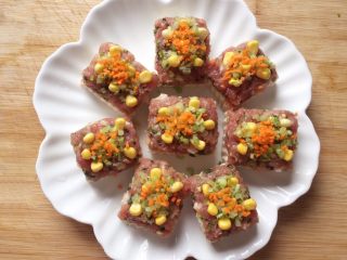 12、吃豆腐~肉末蒸豆腐,然后在肉馅上放上玉米粒,撒上芹菜末和胡萝卜末点缀,放进蒸锅中,大火蒸7、8分钟即可。