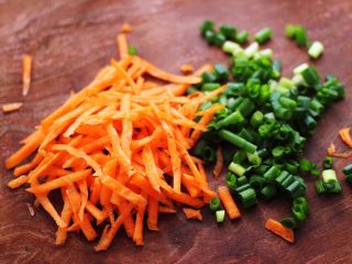 2、槐花胡萝卜鸡蛋饼,把胡萝卜用刀切成丝，小香葱用刀切碎。