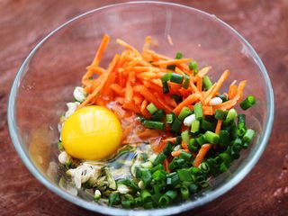 4、槐花胡萝卜鸡蛋饼,放入切丝的胡萝卜和小香葱，再把鸡蛋打散。