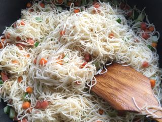 4、美味三色炒面#面条变身计划#,放入细面条翻炒均匀后，加入适量的盐和生抽酱油，蘑菇精。改用筷子不断搅拌面，目的是搅散面，最后撒上葱花，翻炒一会即成。 