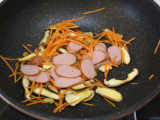 5、快手炒方便面,放入香肠片翻炒。