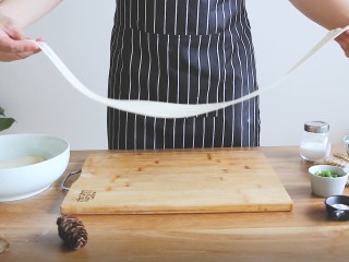 8、陕西油泼面,将面片取出拉住两头，匀力拉甩成长条