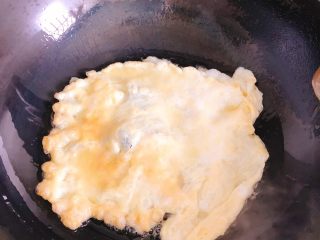 11、蛋包虾仁炒饭-宴请菜之主食,将蛋液倒入油锅煎成蛋饼，一面煎熟后翻面煎，直到两面都煎至金黄色。