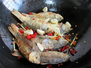 7、黄金小鱼锅贴,鱼煎好后放入辣椒、蒜头、姜丝一起煎一下