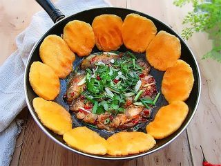 11、黄金小鱼锅贴,贴完一圈后,锅内可以再加一点水盖上锅盖小中火慢慢熬至鱼汤出浓汁,这时候饼子也差不多结脆脆的锅巴,锅内撒入葱蒜、香菜等,即可连锅一起端上桌享受