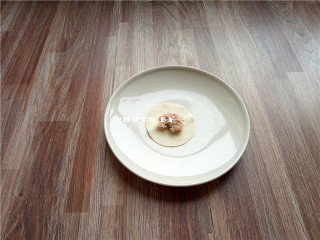 1、金银满钵,提前备好饺子馅、饺子皮；取一张饺子皮，包入适量肉馅；