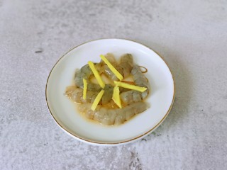 3、快手早餐~虾仁时蔬面疙瘩,虾去皮去头去虾线,放入盘中,加入料酒姜丝腌制5分钟。