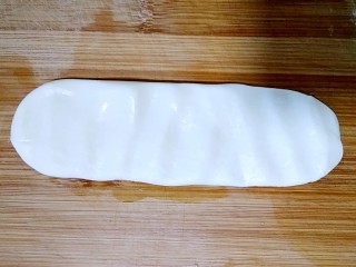 7、陕西油泼面,取一条面，在案板上按扁。