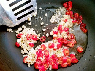 7、蒜苔炒螺丝肉（香辣版）,干辣椒煸好后，快速把姜蒜末和红线椒倒入锅内，煸炒出香味来。