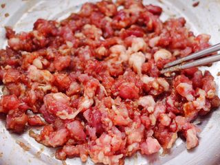 8、西葫芦猪肉发面包,把猪肉馅和所有的调料混合，顺时针方向搅拌上劲。