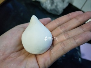 7、花样馒头—寿桃馒头,取一个面团揉圆，然后顶部捏出一个尖头。