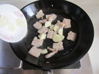 3、扁豆焖面,煸炒至五花肉微微出油时加入蒜片；