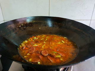 13、香肠土豆焖饭, 煸炒两分钟左右再加入适量水，注意水不要太多哦，不然太稀了就影响口感了