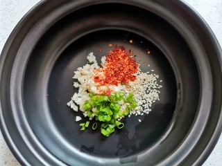 1、酸汤水饺,首先调酸汤汁:1勺蒜末+1勺辣椒粉十1勺白芝麻+1勺葱花。